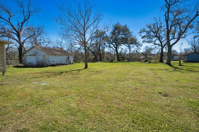 view of yard with a garage and an outbuilding