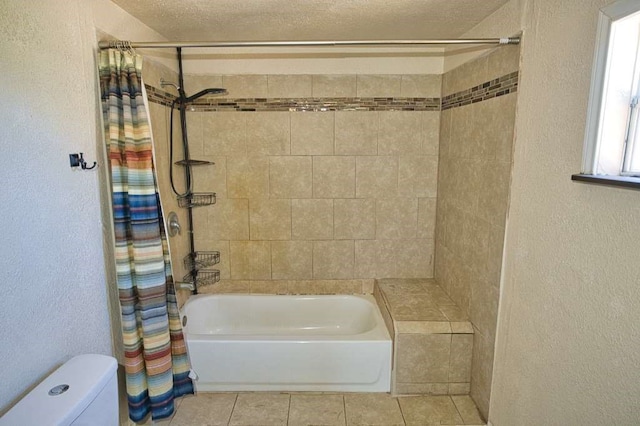 full bath featuring shower / bath combo, a textured wall, toilet, tile patterned flooring, and a textured ceiling