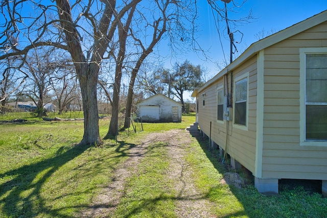 view of yard with dirt driveway and an outdoor structure