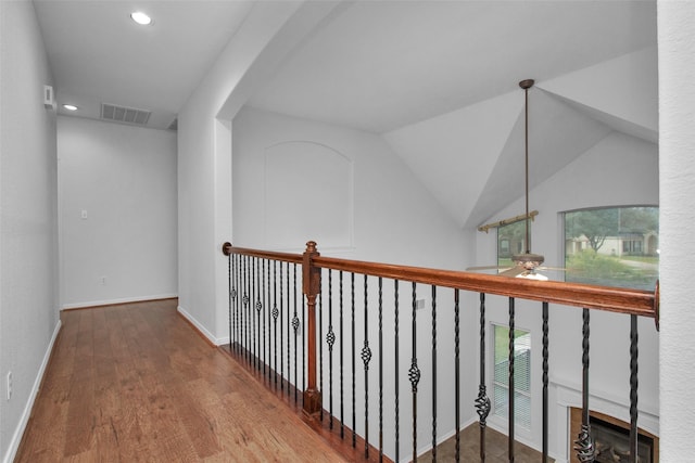 corridor with lofted ceiling and hardwood / wood-style flooring