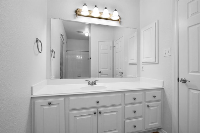 bathroom with vanity and a tile shower