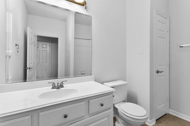 bathroom featuring toilet, vanity, and tile patterned flooring