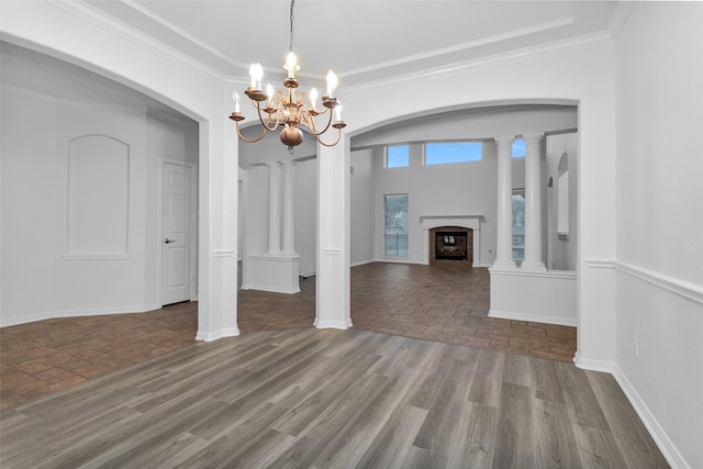 unfurnished dining area featuring wood-type flooring, a chandelier, and ornamental molding