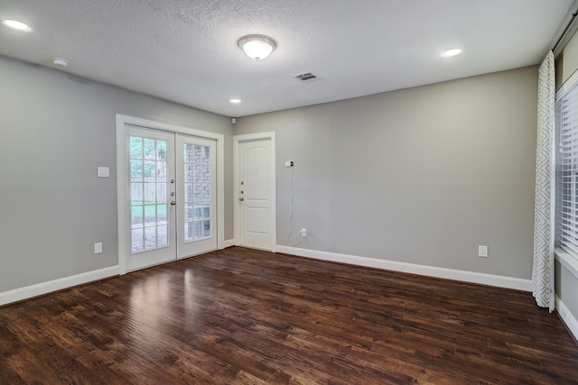 interior space with a textured ceiling, dark hardwood / wood-style flooring, and french doors