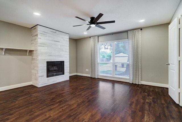 unfurnished living room with ceiling fan, dark wood-type flooring, and a tile fireplace