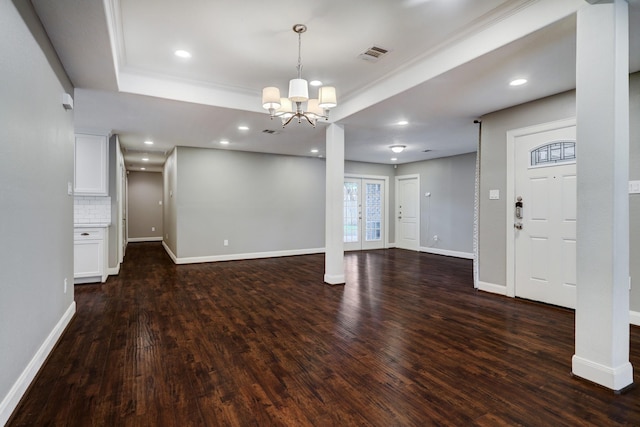 interior space with a tray ceiling, french doors, dark hardwood / wood-style floors, and a chandelier