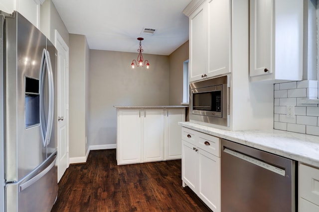 kitchen featuring stainless steel appliances, pendant lighting, white cabinets, and light stone countertops