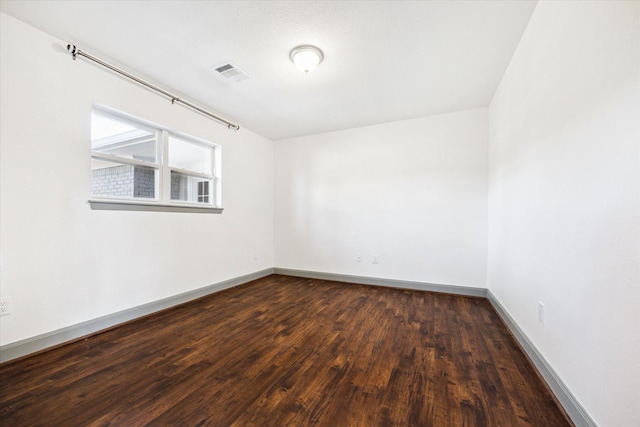 spare room featuring dark wood-type flooring