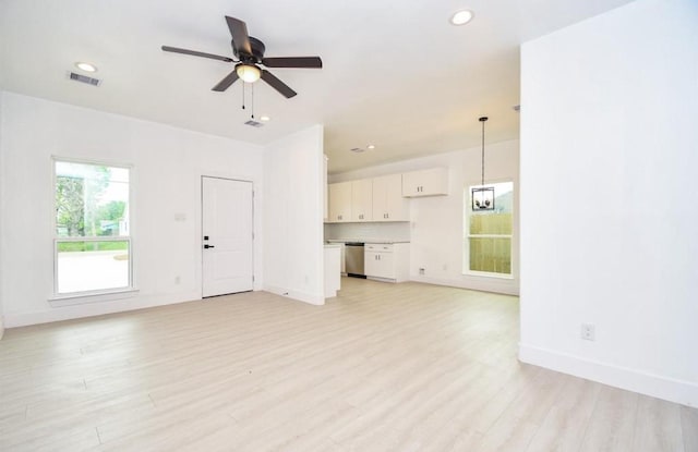 unfurnished living room featuring ceiling fan and light hardwood / wood-style floors