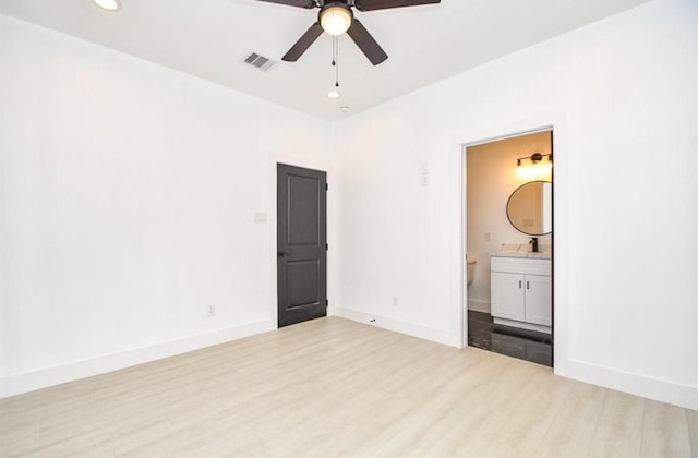 unfurnished bedroom with ensuite bath, sink, ceiling fan, and light wood-type flooring