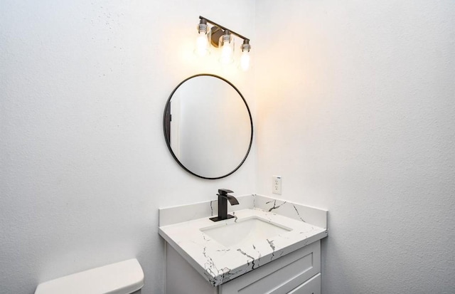 bathroom featuring toilet and vanity