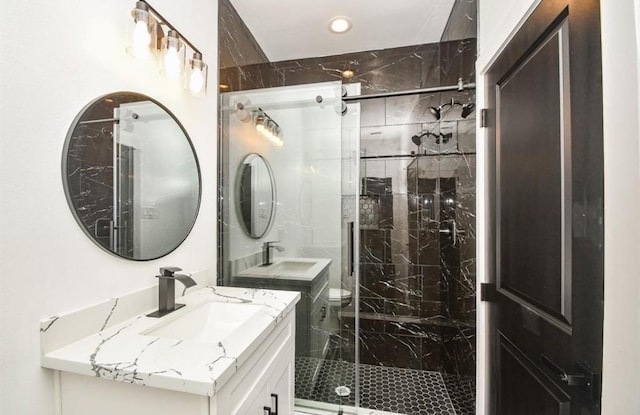 bathroom featuring a shower with shower door and vanity