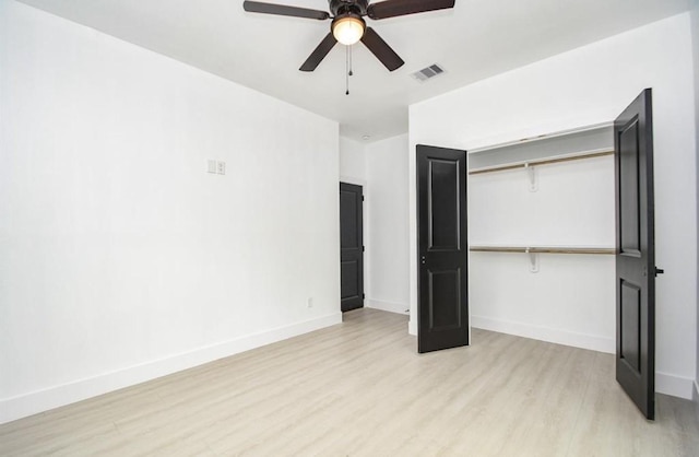 unfurnished bedroom with light wood-type flooring, ceiling fan, and a closet