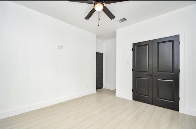 unfurnished bedroom featuring light wood-type flooring, ceiling fan, and a closet