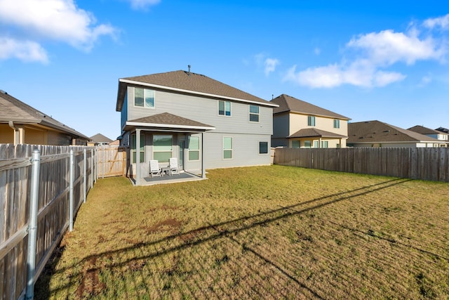 rear view of property featuring a lawn and a patio