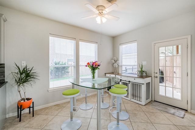 tiled dining room featuring ceiling fan and a healthy amount of sunlight