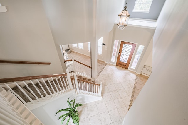 foyer entrance featuring light tile patterned floors and a high ceiling