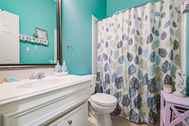 bathroom featuring tile patterned floors, toilet, vanity, and a shower with curtain