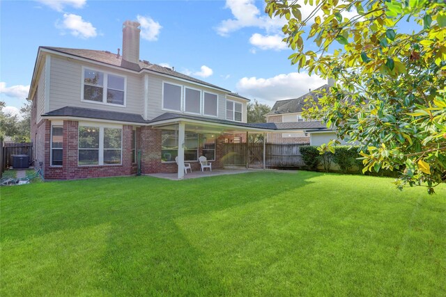 rear view of property featuring central AC unit, a patio area, and a yard