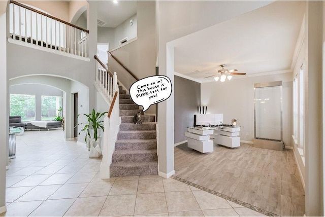 stairway featuring ceiling fan, tile patterned floors, and crown molding