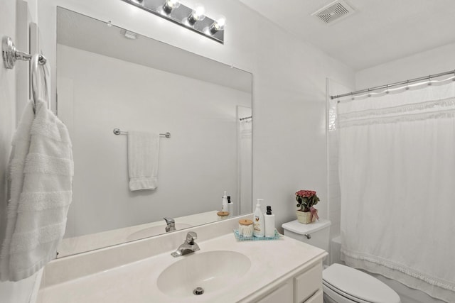 bathroom featuring toilet, vanity, and curtained shower