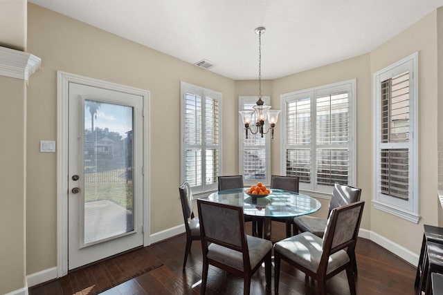 dining space with a wealth of natural light, dark hardwood / wood-style flooring, and a chandelier