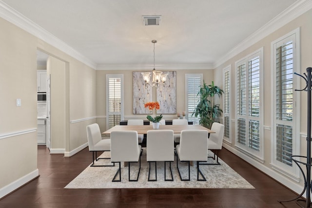 dining area featuring a wealth of natural light, dark hardwood / wood-style flooring, crown molding, and a chandelier