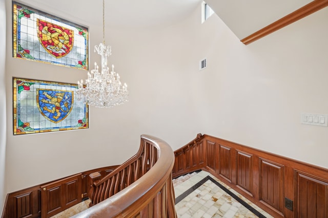 stairway featuring a notable chandelier