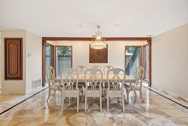 dining space with a healthy amount of sunlight and an inviting chandelier