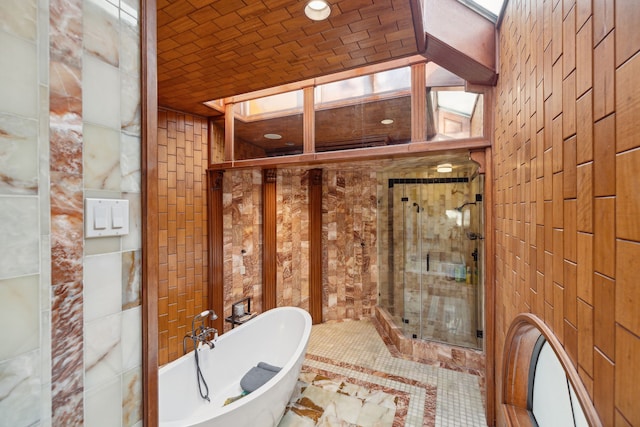 bathroom featuring brick ceiling, a washtub, and a skylight