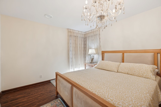 bedroom featuring dark wood-type flooring and a notable chandelier