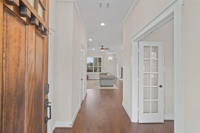 corridor with hardwood / wood-style flooring and crown molding