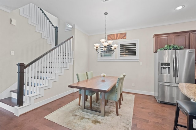 dining space featuring crown molding, wood-type flooring, and a chandelier