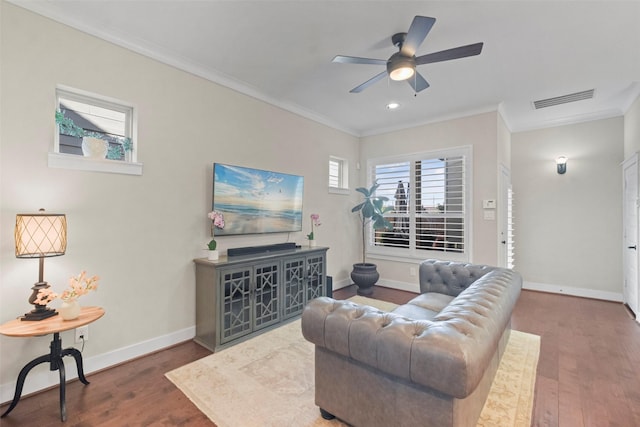 living room with dark wood-type flooring, ceiling fan, and ornamental molding