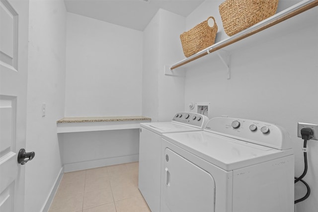 laundry room with light tile patterned floors and washing machine and clothes dryer