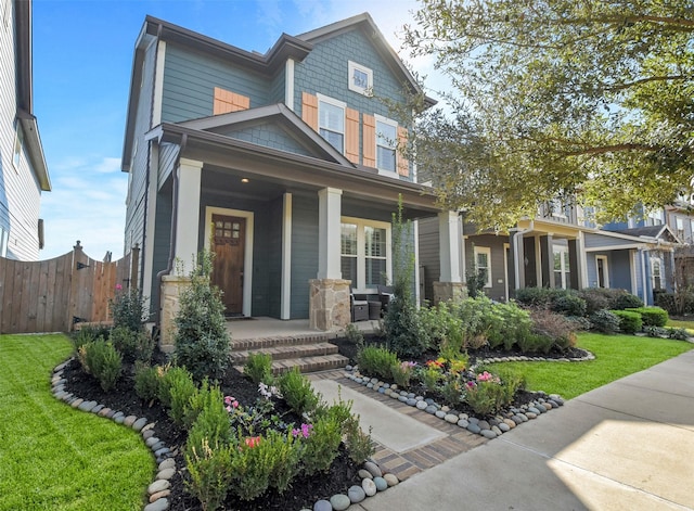 craftsman-style home featuring a front yard and covered porch