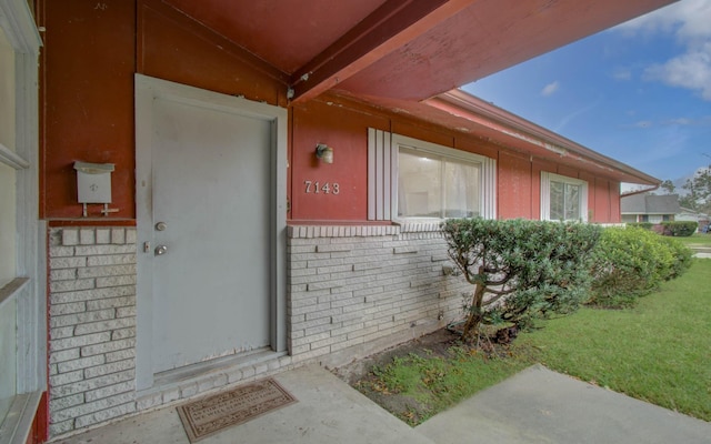 view of exterior entry featuring a yard