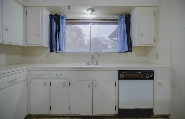 kitchen with white cabinets, backsplash, sink, and white dishwasher