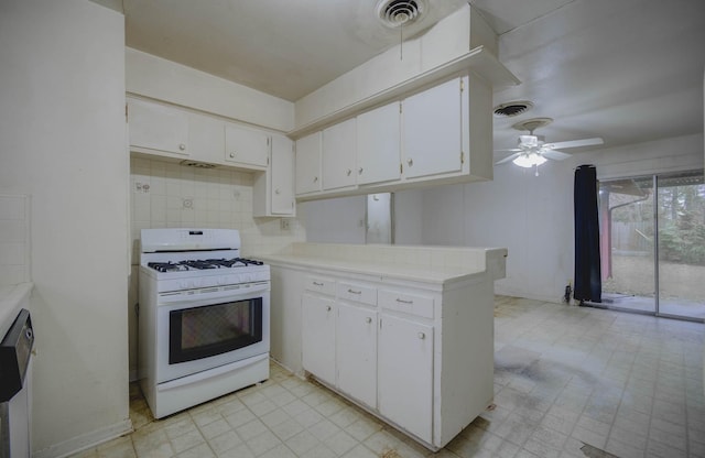 kitchen featuring ceiling fan, kitchen peninsula, white gas stove, and white cabinetry