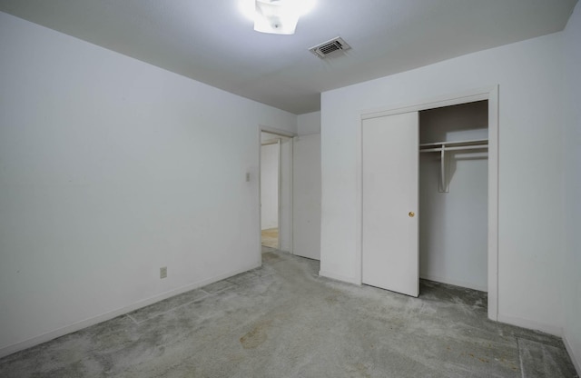 unfurnished bedroom featuring light carpet and a closet