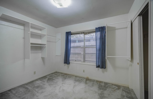 walk in closet featuring light colored carpet