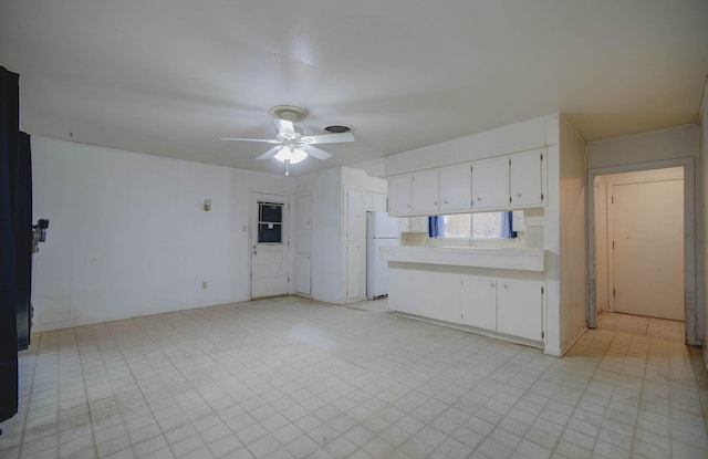 kitchen featuring ceiling fan, white cabinetry, and white fridge