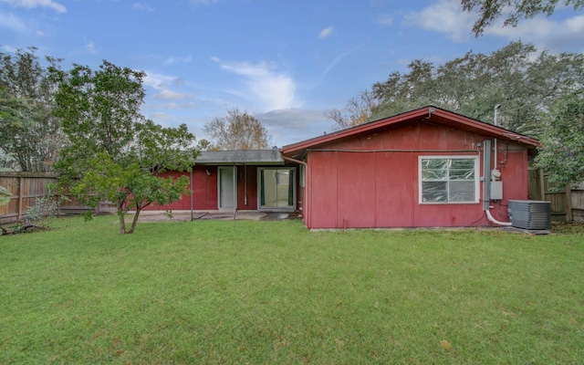 back of property with cooling unit and a lawn