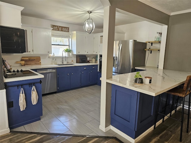 kitchen featuring white cabinets, stainless steel appliances, pendant lighting, and sink