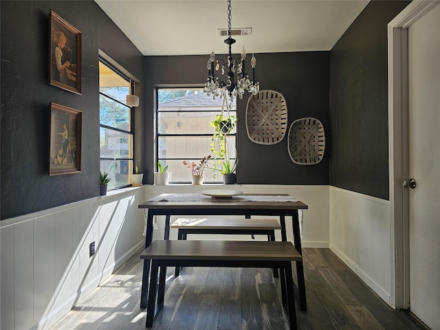 dining room with hardwood / wood-style floors and an inviting chandelier