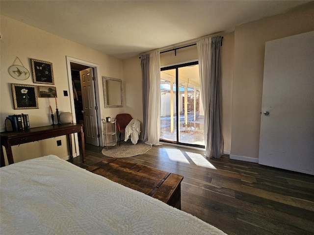 unfurnished bedroom featuring access to exterior, dark hardwood / wood-style floors, and multiple windows