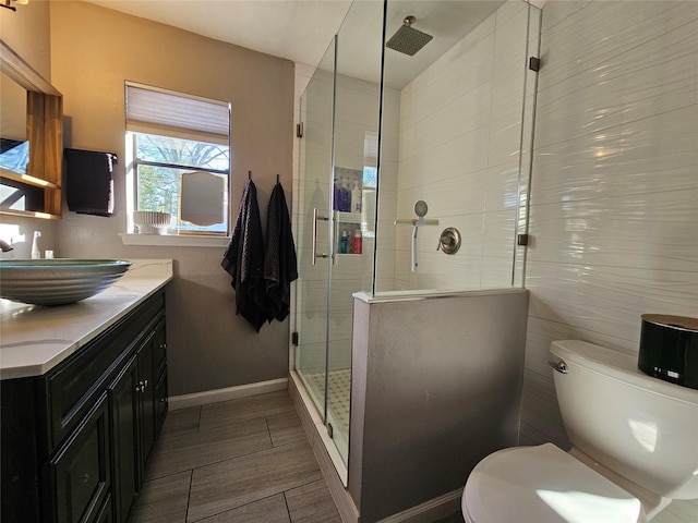 bathroom featuring an enclosed shower, vanity, and toilet