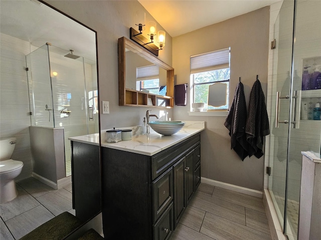 bathroom with a shower with door, toilet, and vanity