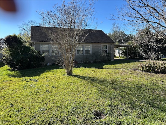 rear view of property featuring a yard and a carport