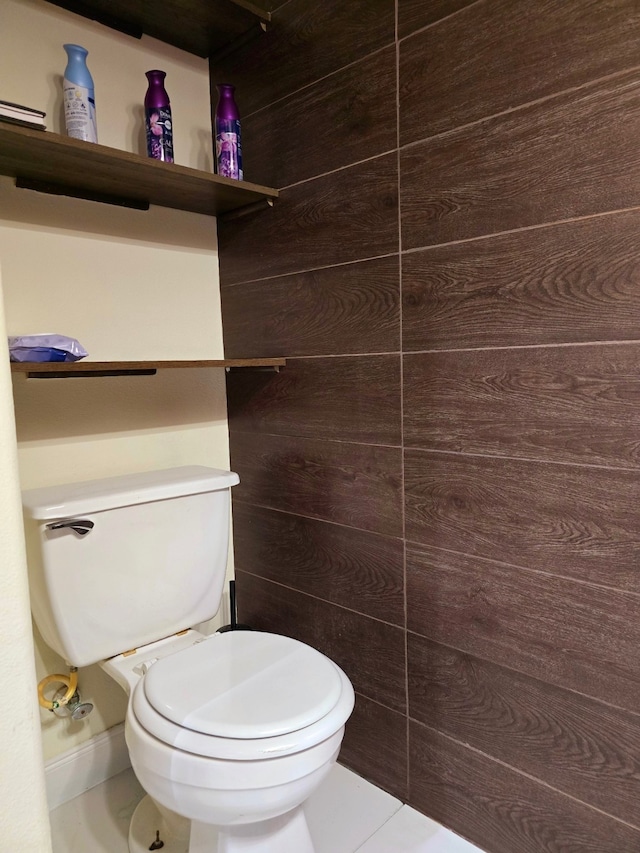 bathroom with toilet and wooden walls